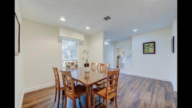 dining area featuring a textured ceiling and dark wood-type flooring