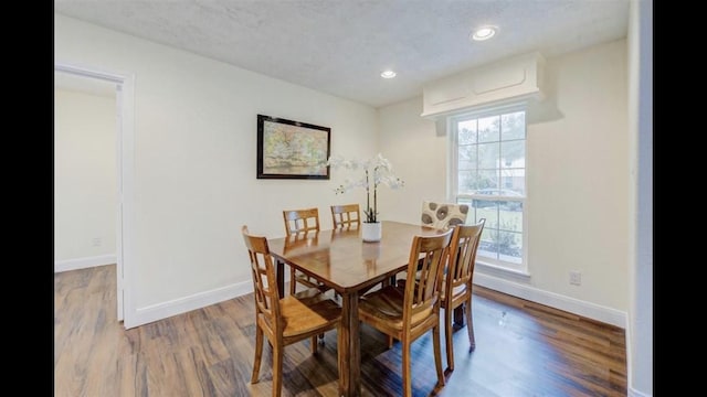 dining room featuring dark hardwood / wood-style flooring and a textured ceiling