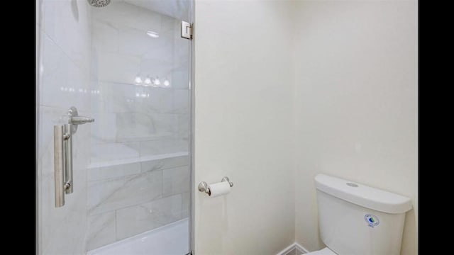 bathroom featuring an enclosed shower and toilet