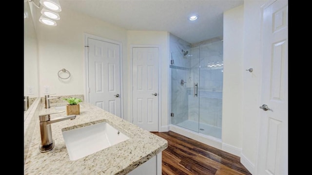 bathroom featuring hardwood / wood-style floors, vanity, and walk in shower