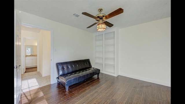 sitting room featuring ceiling fan and dark wood-type flooring