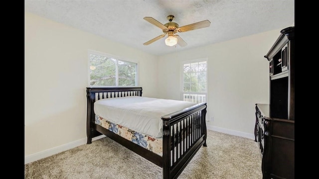 carpeted bedroom with ceiling fan and a textured ceiling