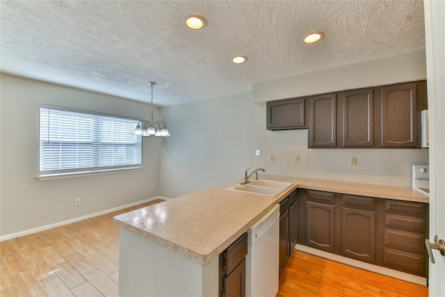 kitchen with sink, a notable chandelier, kitchen peninsula, white dishwasher, and light hardwood / wood-style floors