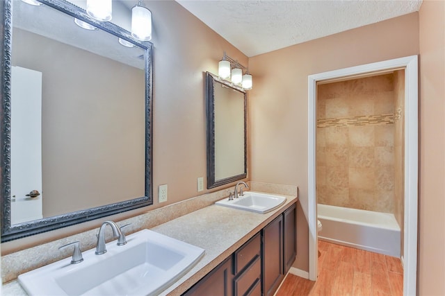 bathroom with toilet, vanity, a textured ceiling, and hardwood / wood-style flooring