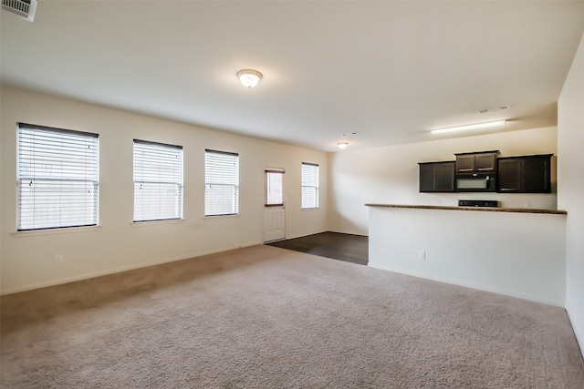 unfurnished living room featuring dark carpet