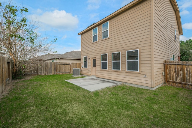 back of property with a patio area, a yard, and central AC