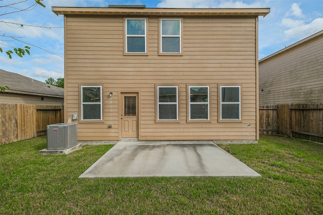 back of house featuring central AC unit, a patio area, and a lawn