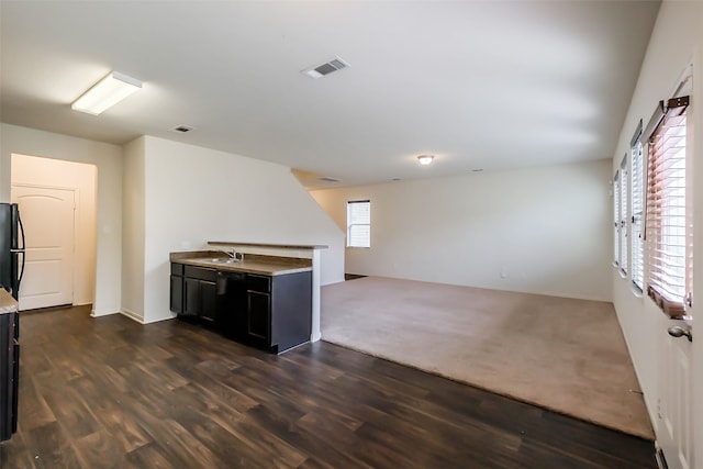 kitchen with black refrigerator, dark wood-type flooring, and sink