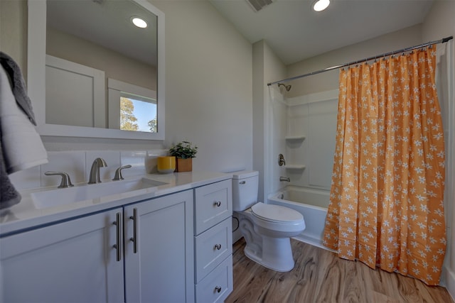 full bathroom featuring vanity, toilet, wood-type flooring, and shower / tub combo