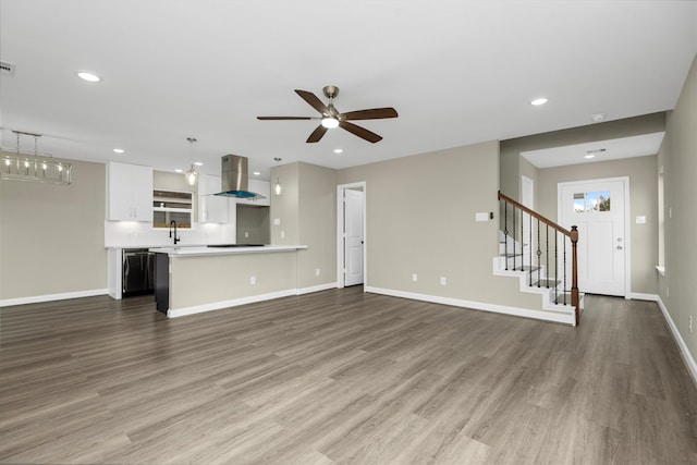 unfurnished living room featuring hardwood / wood-style floors, ceiling fan, and sink