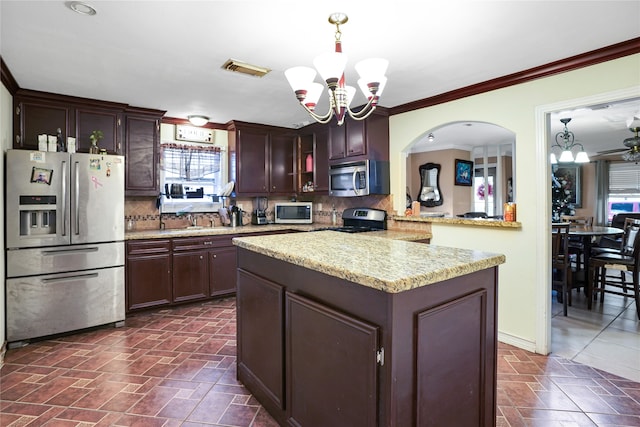 kitchen featuring decorative light fixtures, an inviting chandelier, stainless steel appliances, and tasteful backsplash