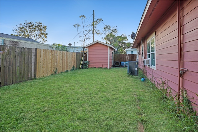 view of yard featuring central AC, cooling unit, and a shed