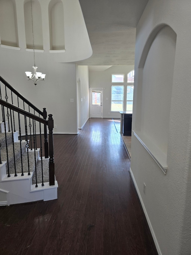 corridor with a chandelier and dark hardwood / wood-style floors