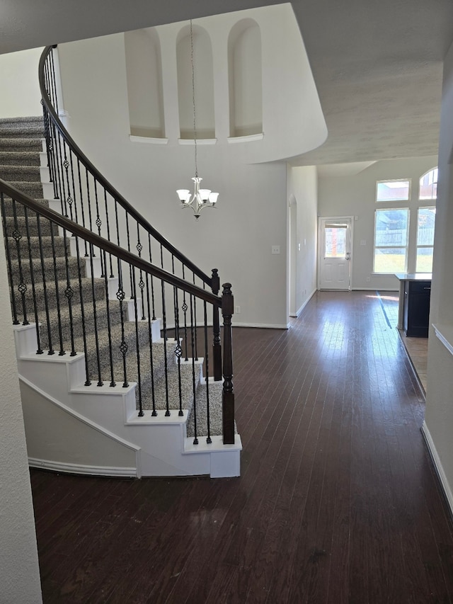 staircase with a chandelier and hardwood / wood-style flooring