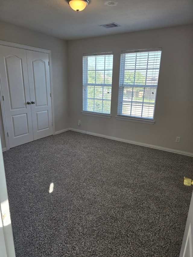 spare room featuring dark carpet