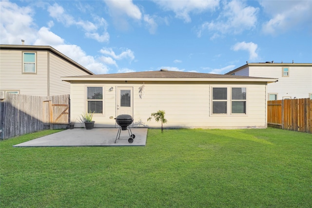 rear view of house with a lawn and a patio