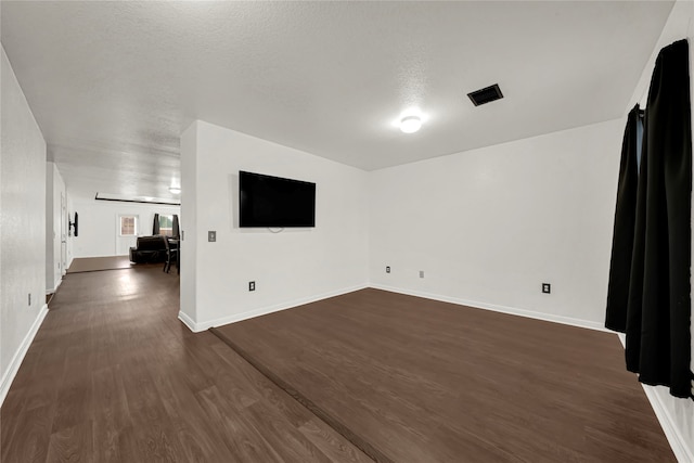 spare room featuring dark hardwood / wood-style flooring and a textured ceiling