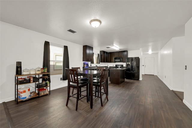 dining area featuring a textured ceiling and dark hardwood / wood-style floors