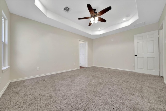 12466 Royal Lake Dr, Conroe, TX 77303 - carpeted empty room with visible vents, baseboards, a tray ceiling, recessed lighting, and a ceiling fan