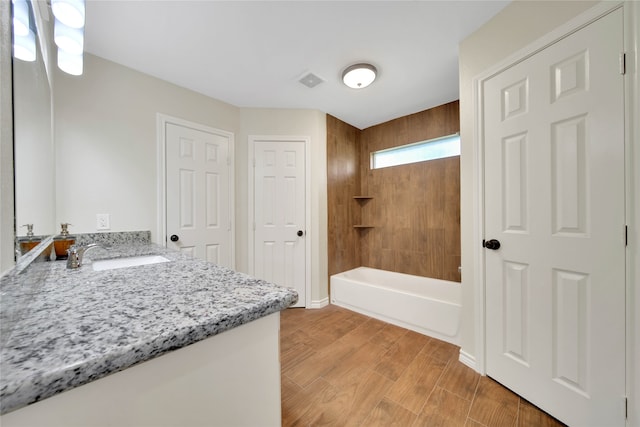 bathroom with vanity,  shower combination, and hardwood / wood-style flooring