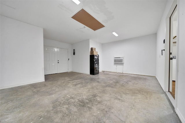 12466 Royal Lake Dr, Conroe, TX 77303 - unfurnished living room with baseboards, concrete floors, attic access, and a wall unit AC