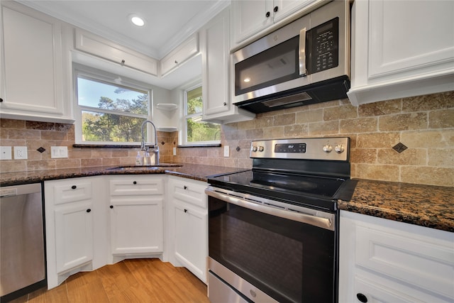 kitchen with dark stone countertops, sink, white cabinets, and stainless steel appliances