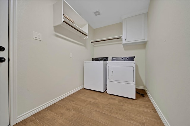 12466 Royal Lake Dr, Conroe, TX 77303 - laundry area with washer and dryer, cabinet space, baseboards, and light wood finished floors