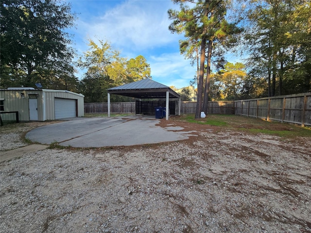 view of yard with an outbuilding, a garage, and a carport