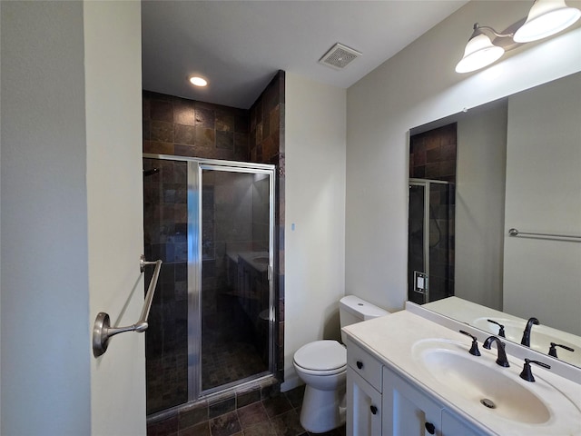 bathroom featuring vanity, toilet, and a shower with shower door