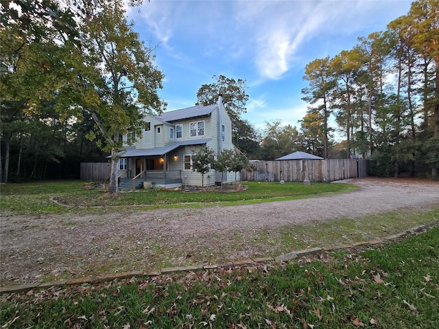 back of property featuring covered porch and a lawn