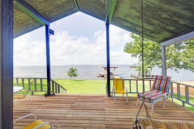 wooden deck with a yard and a water view