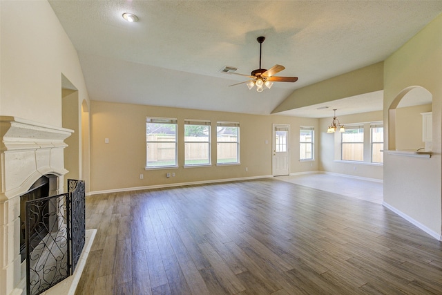 unfurnished living room with ceiling fan, wood-type flooring, a textured ceiling, and lofted ceiling