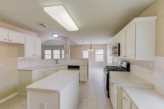 kitchen featuring a center island, sink, hanging light fixtures, tasteful backsplash, and stainless steel appliances