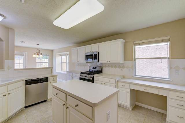 kitchen with decorative backsplash, hanging light fixtures, a kitchen island, and stainless steel appliances