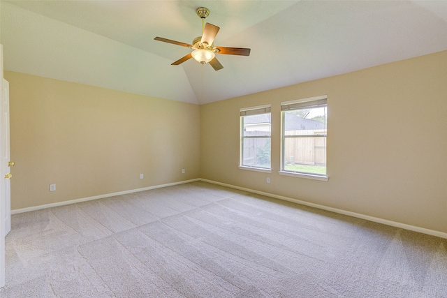 carpeted spare room with ceiling fan and vaulted ceiling