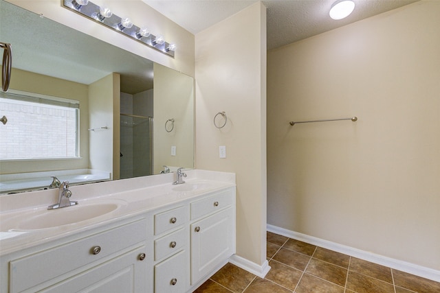 bathroom with vanity, shower with separate bathtub, a textured ceiling, and tile patterned floors