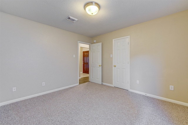 carpeted spare room with a textured ceiling