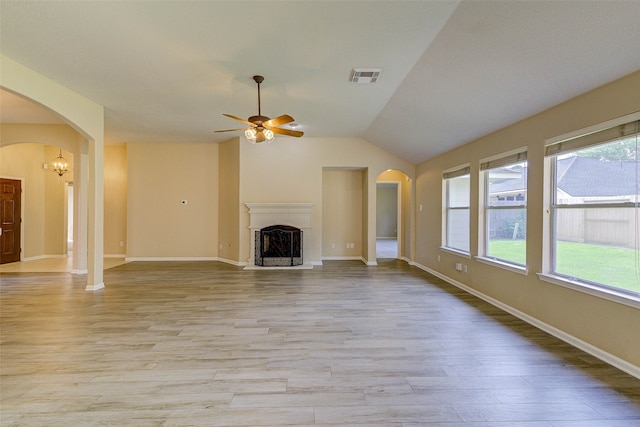 unfurnished living room featuring ceiling fan with notable chandelier, light hardwood / wood-style floors, and lofted ceiling