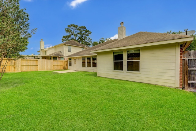 rear view of house featuring a lawn