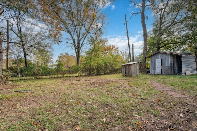 view of yard with an outbuilding, fence, and a shed