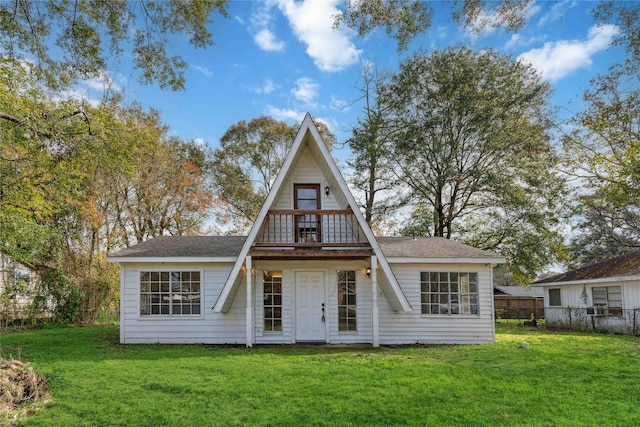 view of front facade featuring a front lawn, fence, and roof with shingles