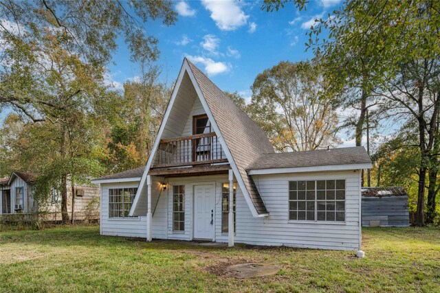 view of front of home with a balcony and a front yard