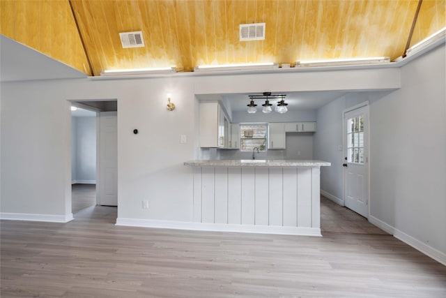 kitchen with kitchen peninsula, sink, wood ceiling, and light hardwood / wood-style floors