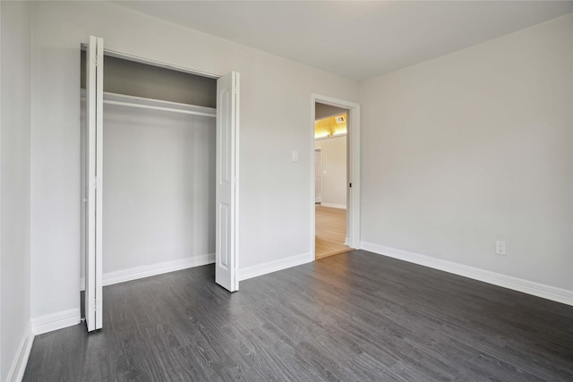 unfurnished bedroom featuring dark hardwood / wood-style flooring and a closet