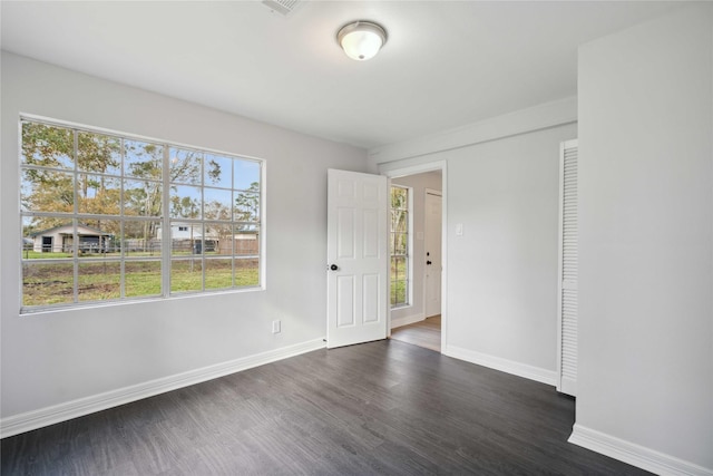 spare room with dark wood finished floors and baseboards