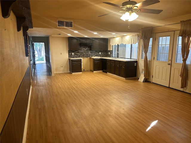 kitchen with decorative backsplash, plenty of natural light, light hardwood / wood-style floors, and dishwasher