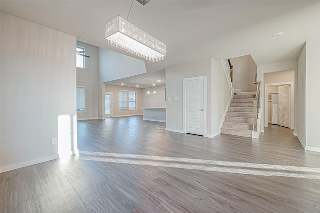 unfurnished living room featuring hardwood / wood-style floors and an inviting chandelier