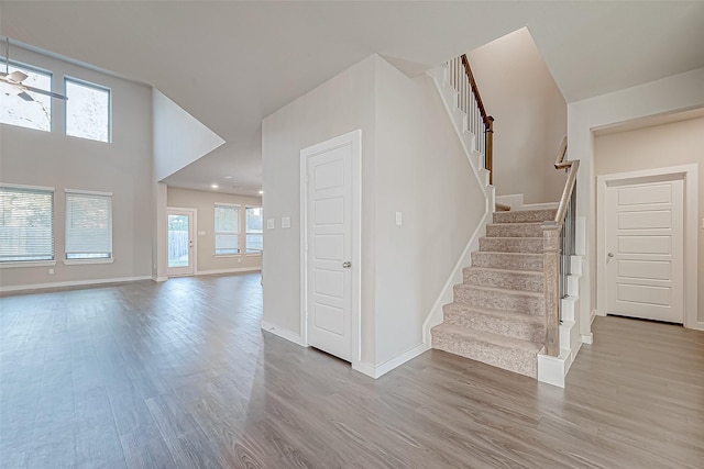 stairway with hardwood / wood-style flooring and a high ceiling