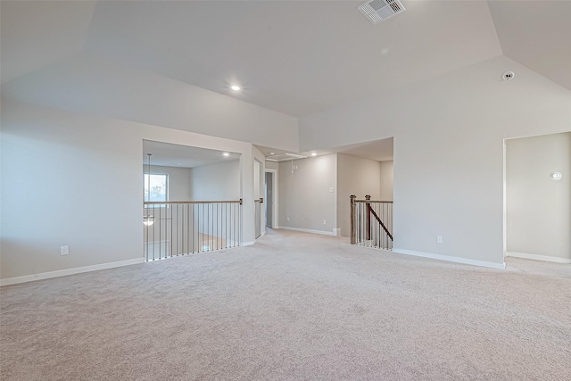 unfurnished room with light colored carpet and vaulted ceiling