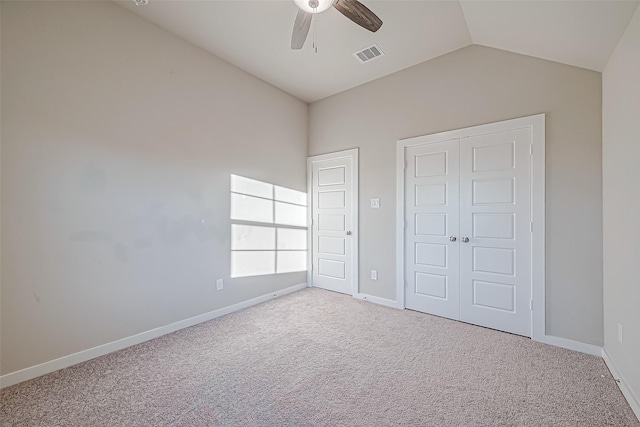 unfurnished bedroom with carpet, ceiling fan, lofted ceiling, and a closet